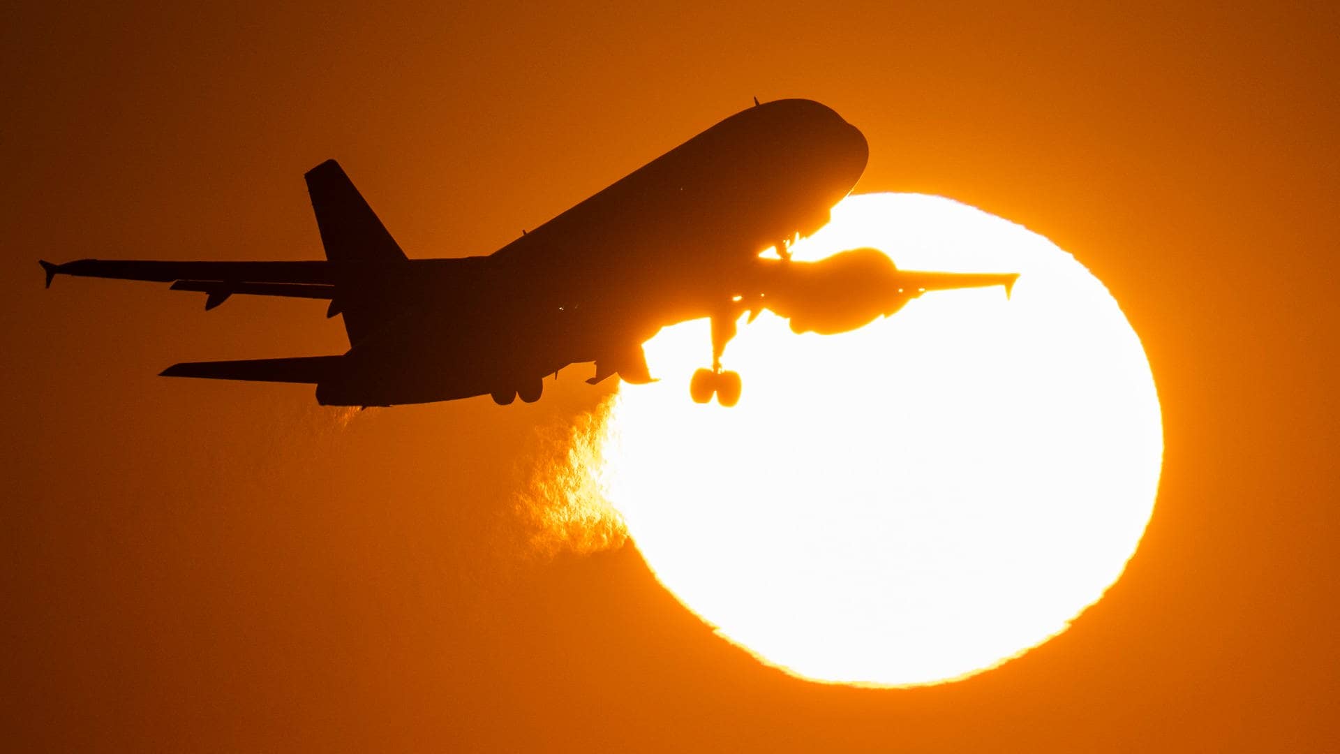 Ein Flugzeug startet im Sonnenuntergang (Foto: dpa Bildfunk, picture alliance/dpa | Boris Roessler)