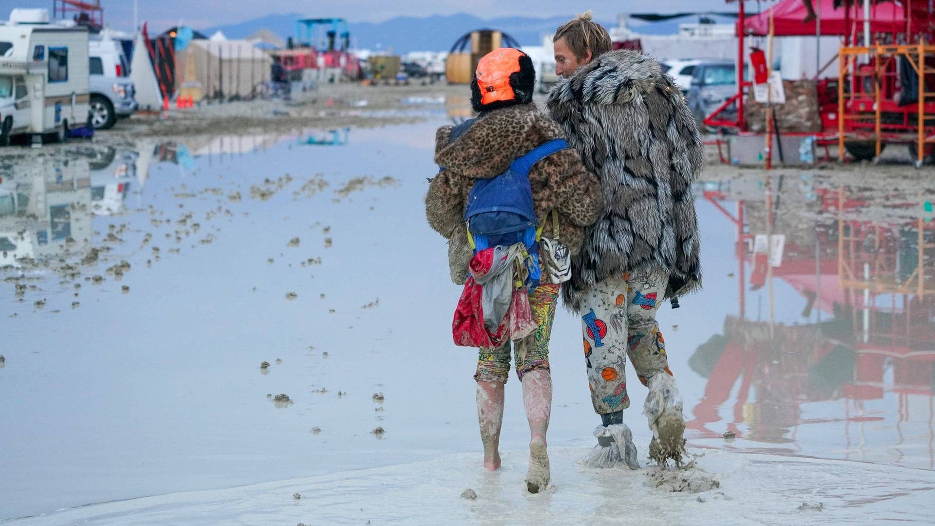 Ein verkleidetes Pärchen läuft durch das Wasser beim Burning Man (Foto: IMAGO, IMAGO/USA TODAY Network)