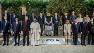 Papst Franziskus, steht zwischen Recep Tayyip Erdoğan, Präsident der Türkei, und Giorgia Meloni, Ministerpräsidentin von Italien, beim Familienfoto beim G7-Gipfel in Italien 2024. (Foto: dpa Bildfunk, picture alliance/dpa | Michael Kappeler) Papst Franziskus, steht zwischen Recep Tayyip Erdoğan, Präsident der Türkei, und Giorgia Meloni, Ministerpräsidentin von Italien, beim Familienfoto beim G7-Gipfel in Italien 2024.