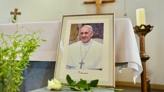 Ein Bild des verstorbenen Papstes Franziskus steht vor dem Altar in der katholischen Kirchengemeinde St. Bonifatius. (Foto: dpa Bildfunk, picture alliance/dpa | Matthias Bein) Ein Bild des verstorbenen Papstes Franziskus steht vor dem Altar in der katholischen Kirchengemeinde St. Bonifatius.