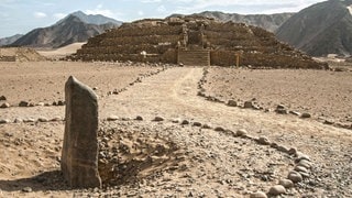 Eine etwa 5.000 Jahre Pyramide im peruanischen Caral. Davor steht in den Sand vergraben ein Monolith. (Foto: dpa Bildfunk, picture alliance / dpa | Caral Archaeological Area / Hand) Eine etwa 5.000 Jahre Pyramide im peruanischen Caral. Davor steht in den Sand vergraben ein Monolith.