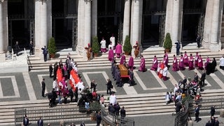 Trauerfeier in Rom: Der Sarg mit dem verstorbenen Papst Franziskus wird in die Kirche Santa Maria Maggiore gebracht, wo er beerdigt wird. (Foto: dpa Bildfunk, picture alliance/dpa/AP | Luca Bruno) Trauerfeier in Rom: Der Sarg mit dem verstorbenen Papst Franziskus wird in die Kirche Santa Maria Maggiore gebracht, wo er beerdigt wird.