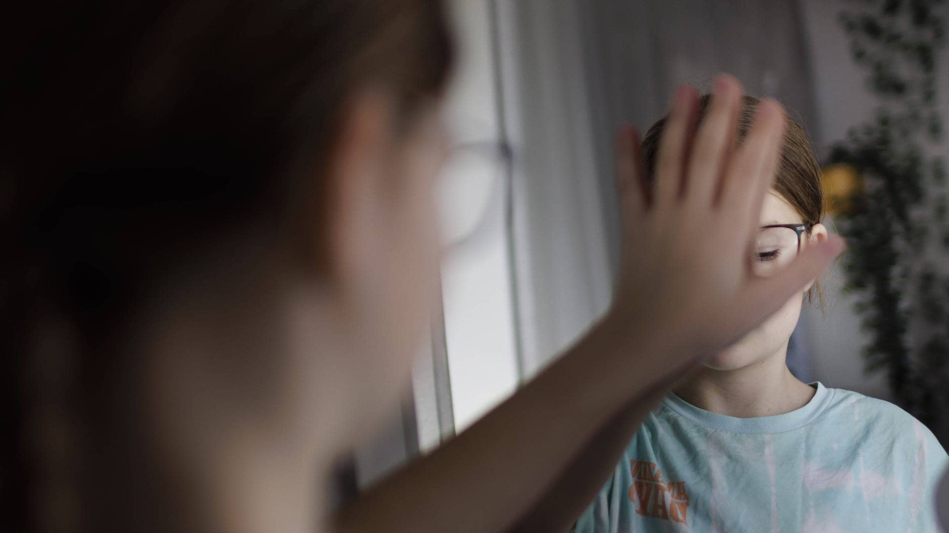 Ein Kind bedeckt sein Spiegelbild mit der Hand. (Foto: IMAGO, IMAGO / photothek)