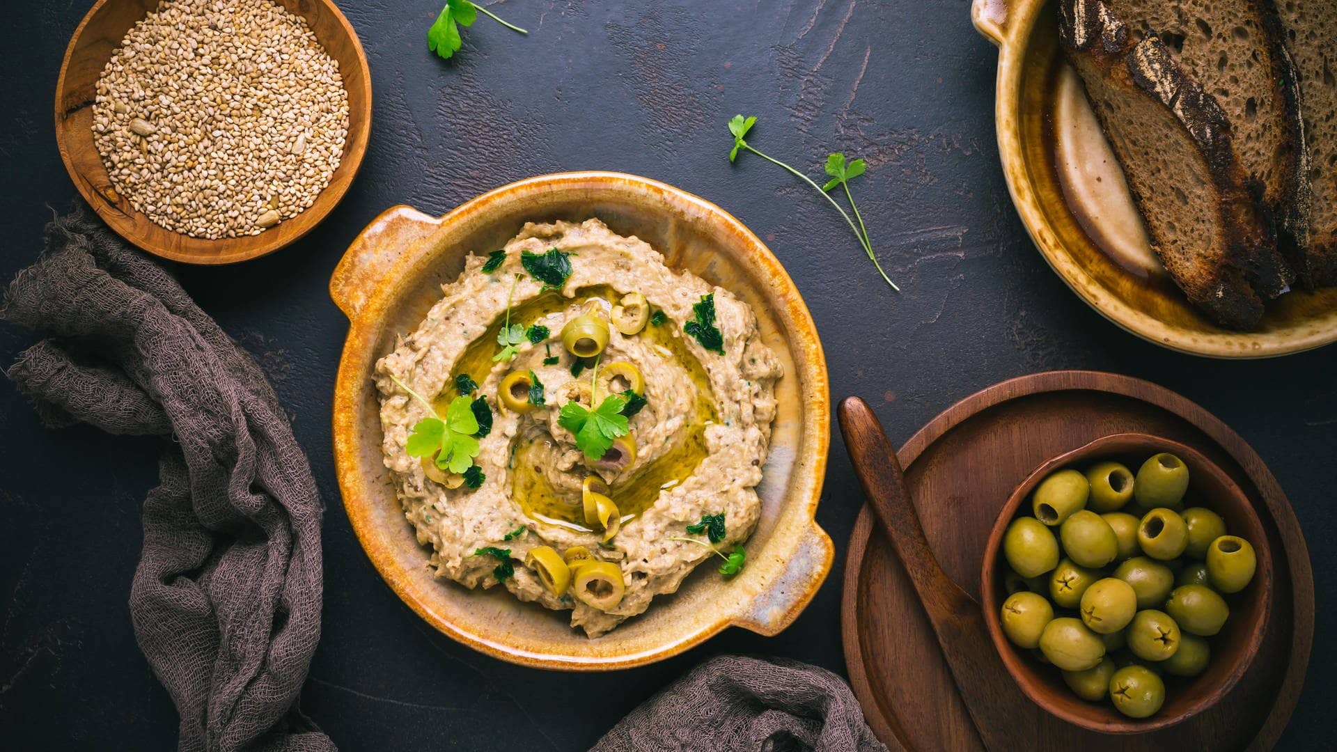 Baba Ghanoush, eine Auberginen-Paste, angerichtet mit Oliven auf einem Teller