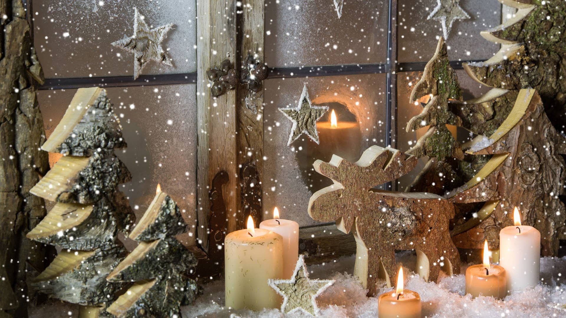 Weihnachtsdeko vor dem Fenster: Mit Tannenzweigen, Kerzen und einer Elch-Figur aus Holz