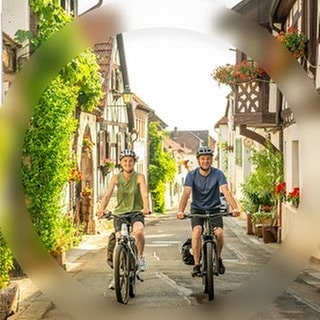 Ein Mann und eine Frau fahren auf den E-Bikes aus dem SWR3 Gewinnspiel der SWR3 E-Bike-Challenge durch SWR3Land und genießen den Frühling.