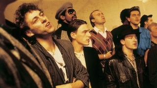 Bob Geldof, Phil Collins und Bono 1984 bei der Aufnahme des Band-Aid-Songs „Do They Know It's Christmas?“ (Foto: picture-alliance / Reportdienste, empics | Brian Aris/Band Aid) Bob Geldof, Phil Collins und Bono 1984 bei der Aufnahme des Band-Aid-Songs „Do They Know It's Christmas?“