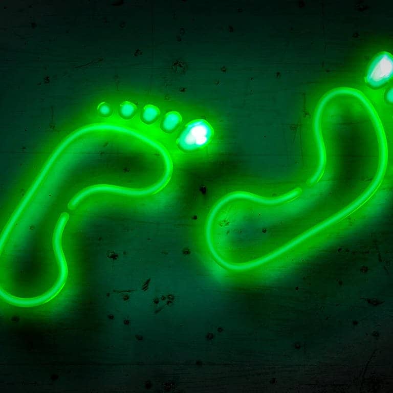 Grüne Neon-Fußabdrücke auf einer Wand – SWR3 New Pop goes green