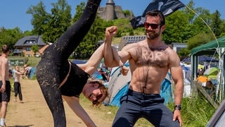 Zwei Campingplatz-Bewohner bei Rock am Ring machen eine Pose aus dem Bereich Acro-Yoga (Foto: SWR3, SWR3 / Ronny Krautz) Zwei Campingplatz-Bewohner bei Rock am Ring machen eine Pose aus dem Bereich Acro-Yoga
