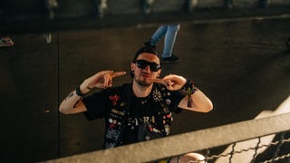 Ein Mann fotografiert durch ein Gitter (Foto: SWR3, SWR3 / Niko Neithardt) Ein Mann fotografiert durch ein Gitter