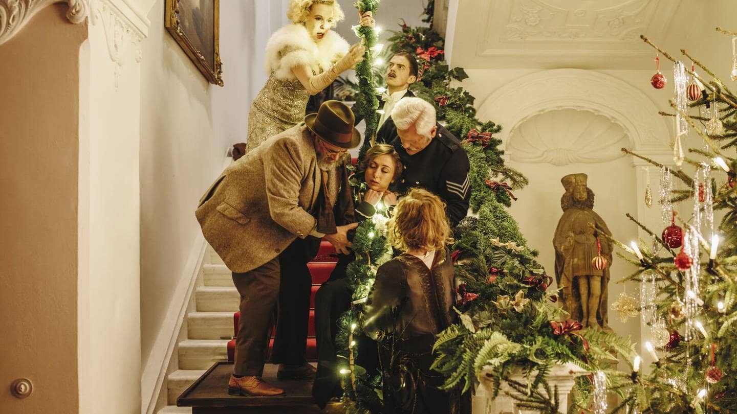 5 Menschen auf einer Treppe, die weihnachtlich dekoriert ist